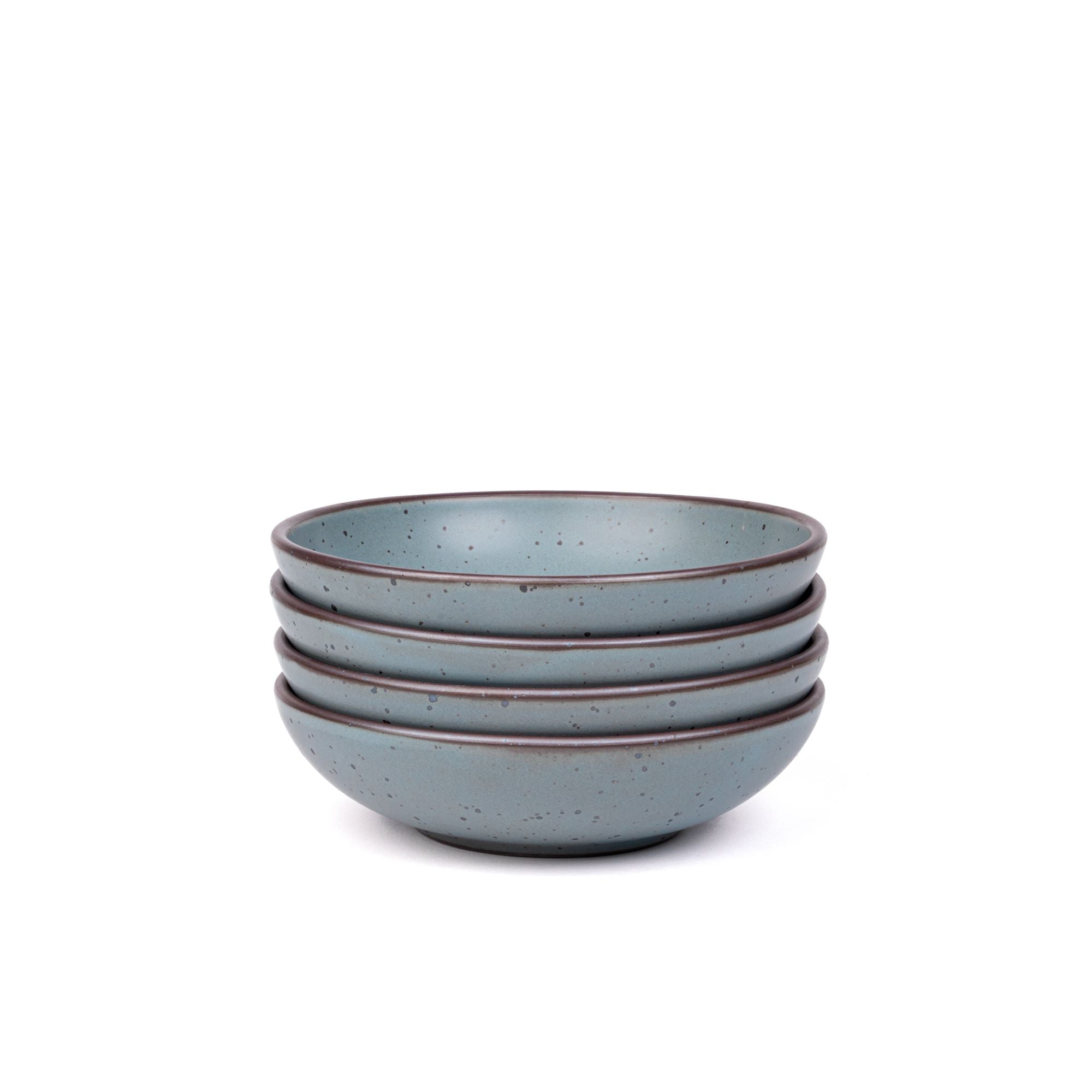 A stack of 4 dinner-sized shallow ceramic bowls in a blue-grey color featuring iron speckles and an unglazed rim