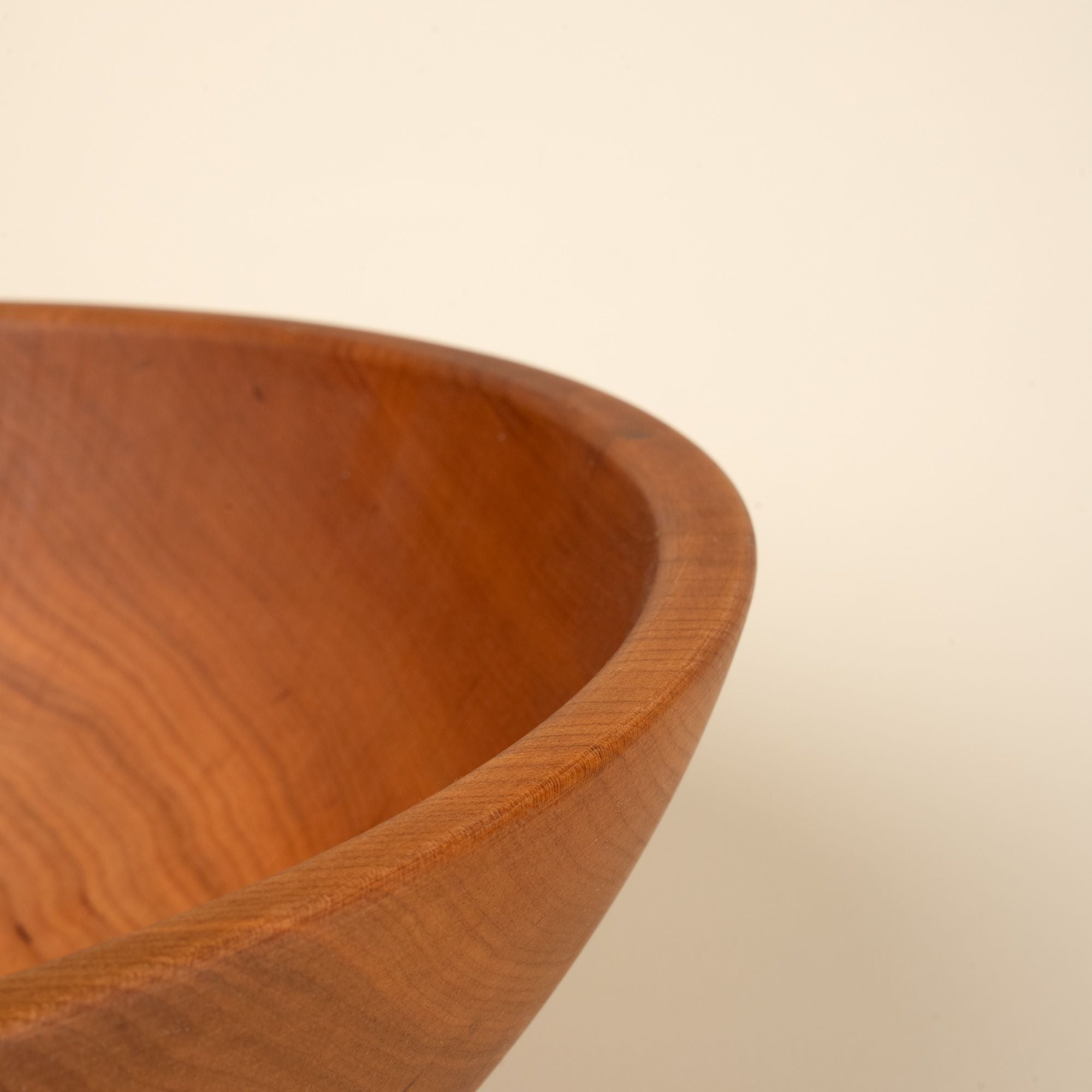A closeup of the edge of a cherry wood bowl