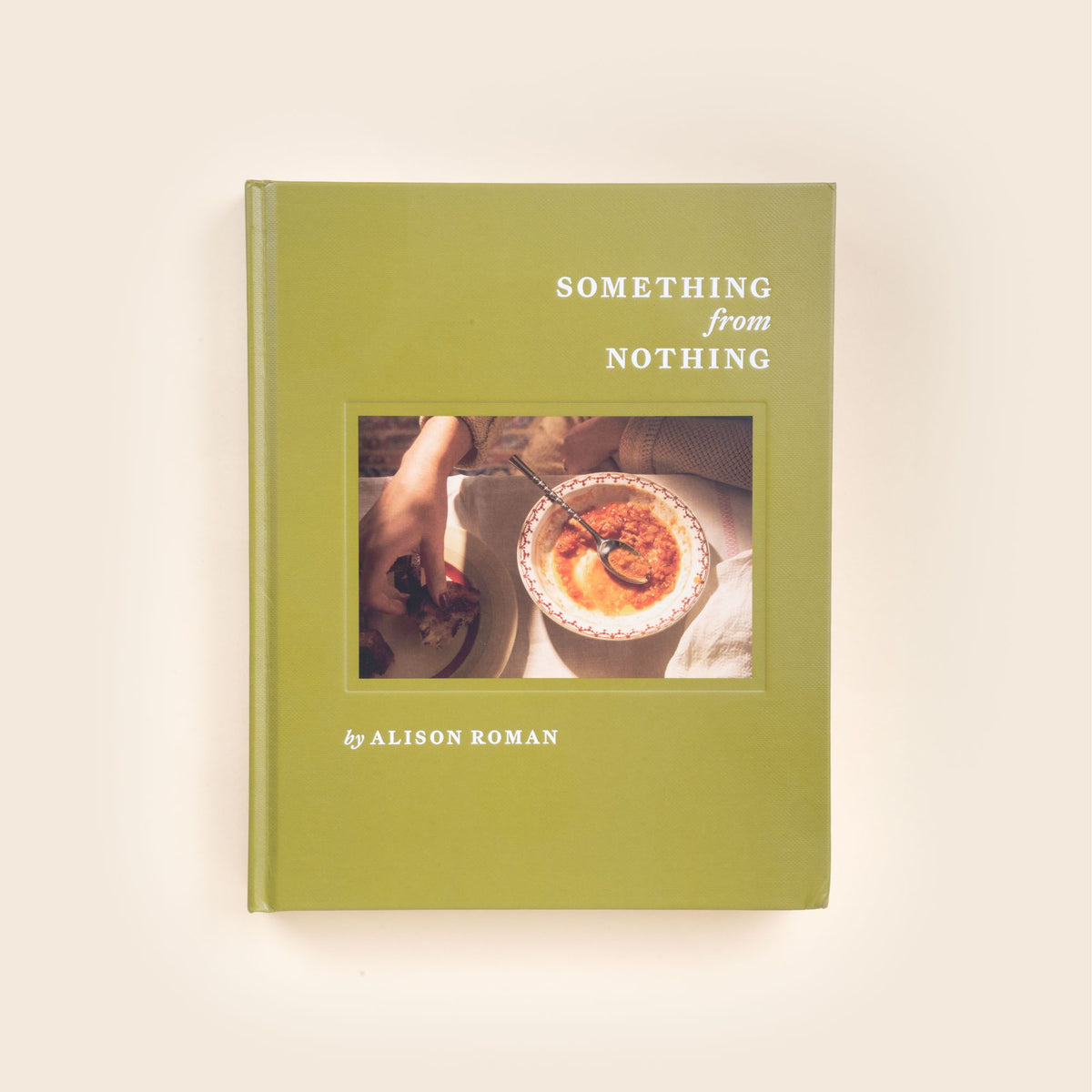 Hardcover cookbook titled Something from Nothing by Alison Roman, with a photo of hands reaching for a bowl of food on the green cover.