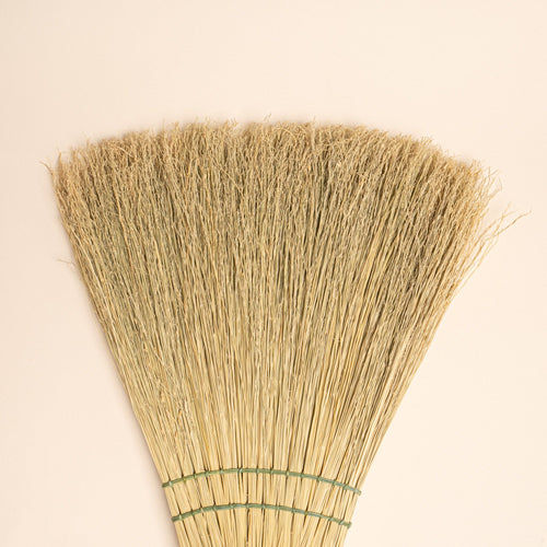 Closeup of the end of a broom with green stitching
