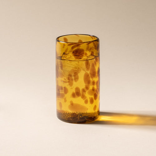 Ice water in a tortoiseshell tall transparent drinking glass