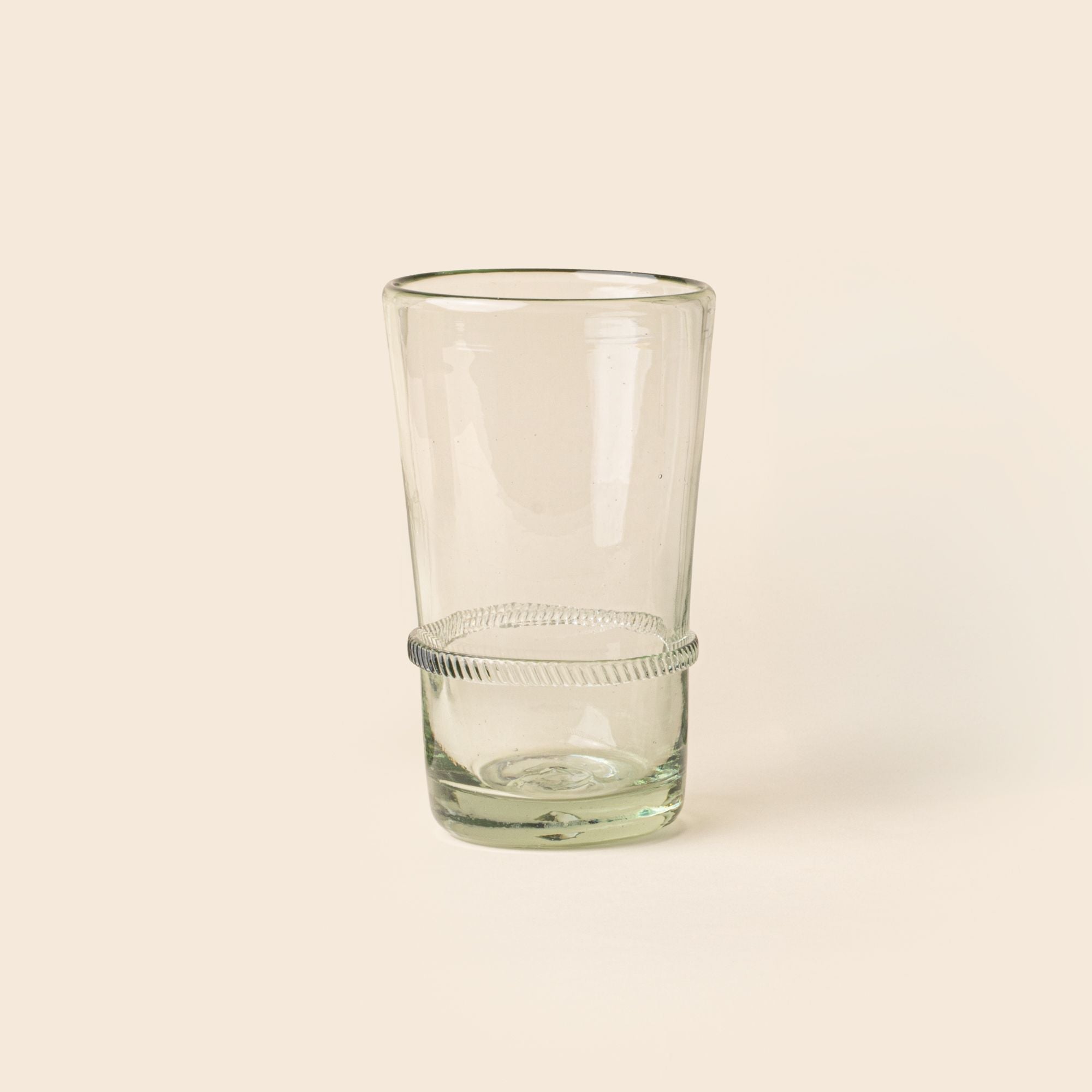 A clear tall recycled glass tumbler with a ridged band detail.