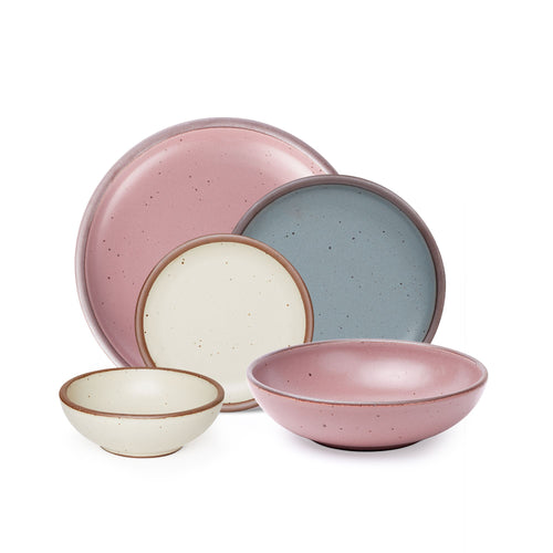 A breakfast bowl, everyday bowl, cake plate, side plate and dinner plate paired together in a dusty mauve pink, blue-grey and warm off-white colors featuring iron speckles