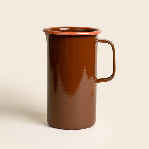 A large enamel pitcher with handle in a red-brown color with an orange rim.
