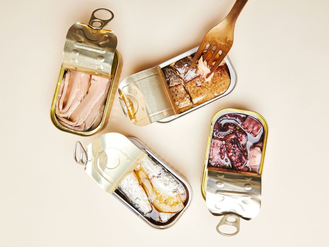 Four open tins of tinned fish