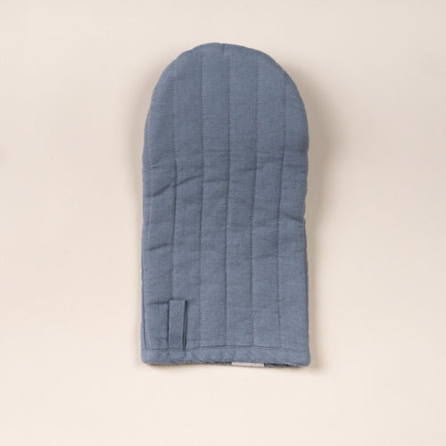 Soft blue linen oven mitt with stitched channels and a small hanging loop, laid flat on a light background.