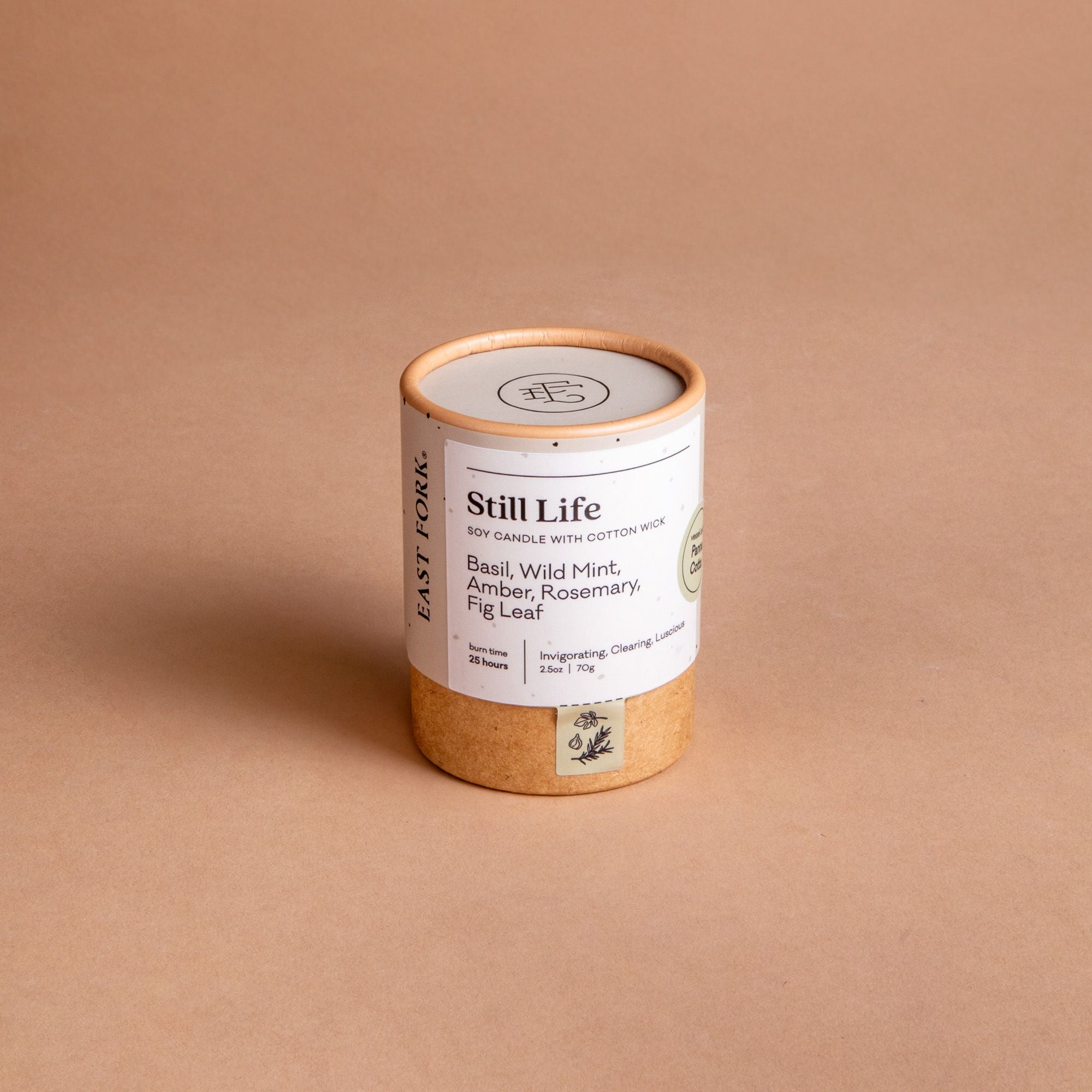 Small cardboard packaging tube with a candle inside with branding on it that says 'Still Life'