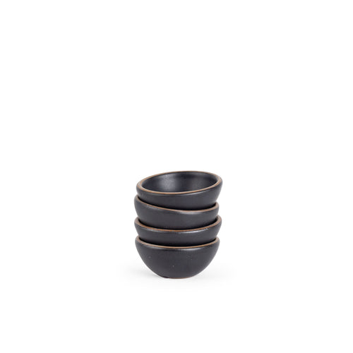 A stack of 4 tiny rounded ceramic bowls in a graphite black color featuring iron speckles and an unglazed rim