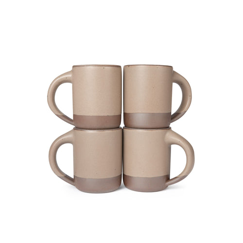 Four medium sized ceramic mugs with handles in a warm pale brown color featuring iron speckles and unglazed rim and bottom base, stacked in sets of 2.