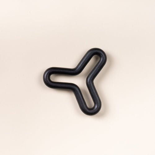 Black wavy trivet shaped like a three-point star on a light neutral background.