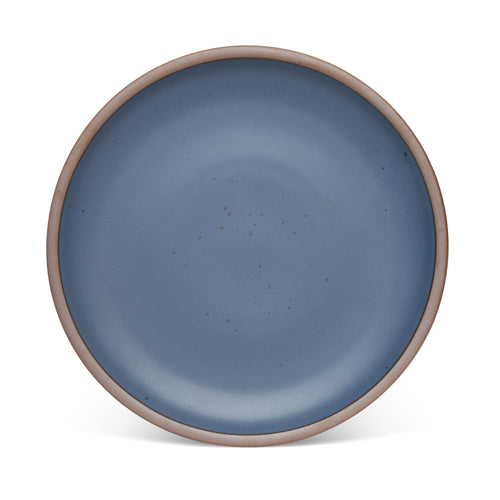 A large ceramic platter in a cool medium blue color featuring iron speckles and an unglazed rim.