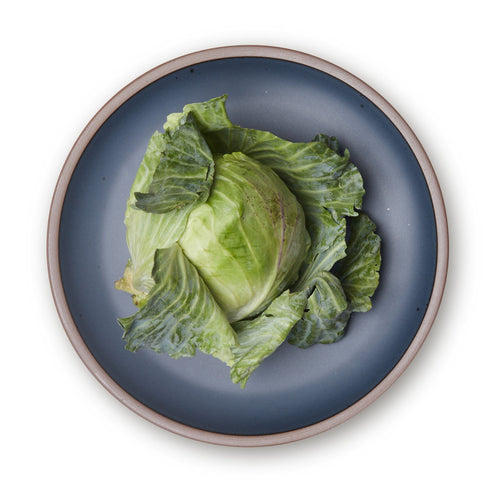 Lettuce on a large ceramic platter in a cool medium blue color featuring iron speckles and an unglazed rim.