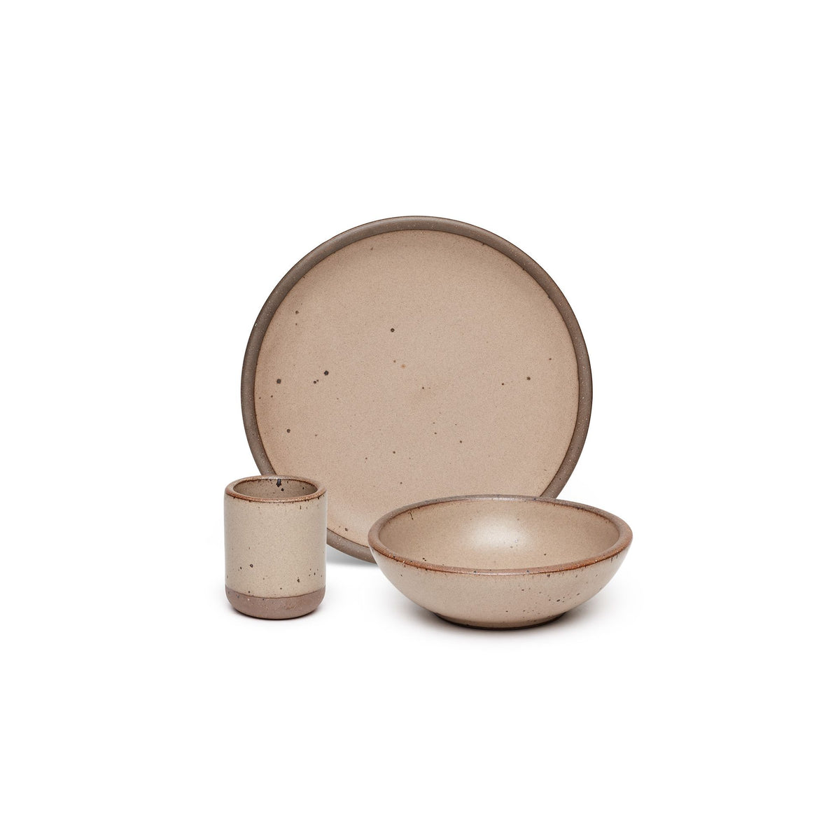 A small tiny cup, a medium sized plate, and a small breakfast bowl paired together in a warm pale brown color featuring iron speckles.
