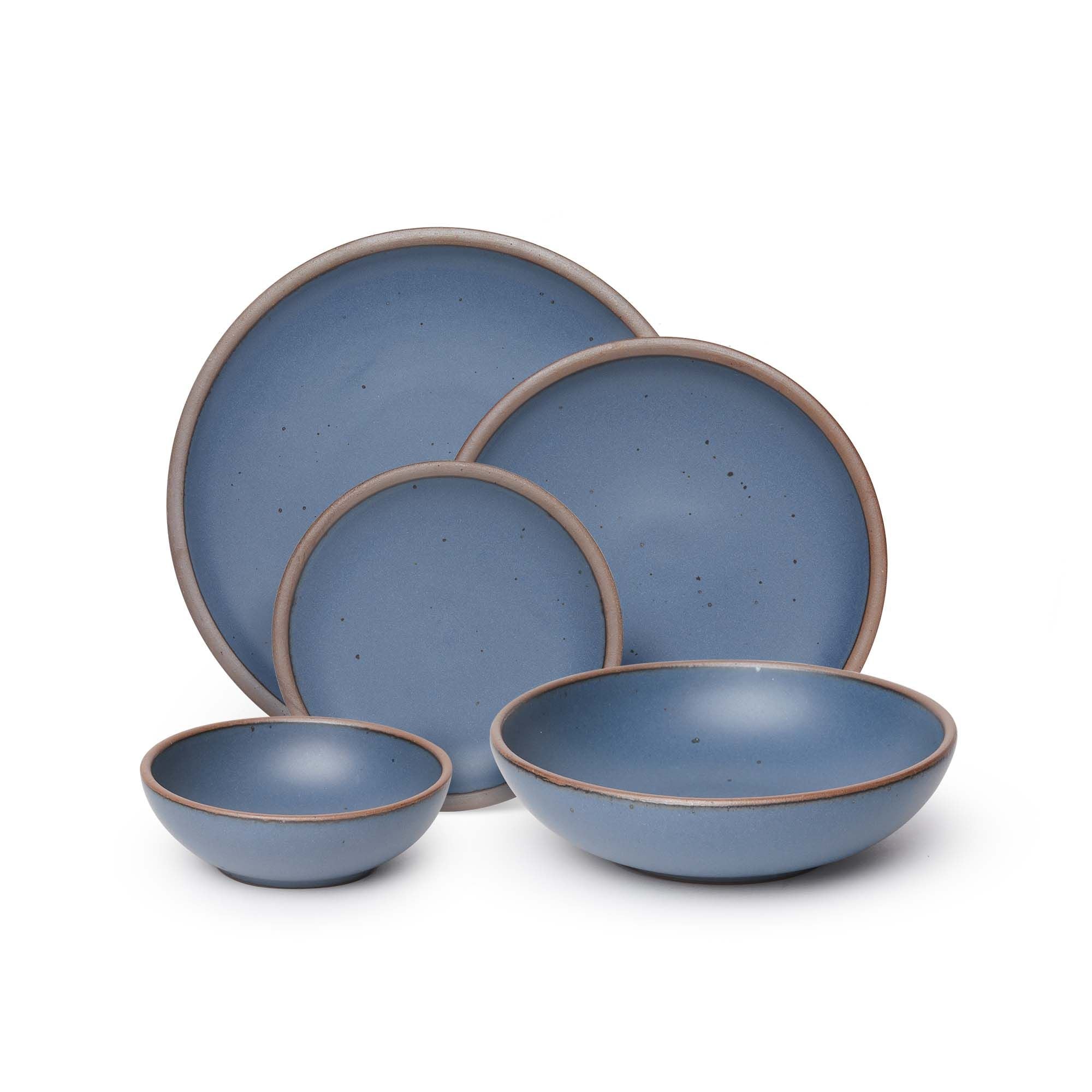 A breakfast bowl, everyday bowl, cake plate, side plate and dinner plate paired together in a cool, medium blue featuring iron speckles