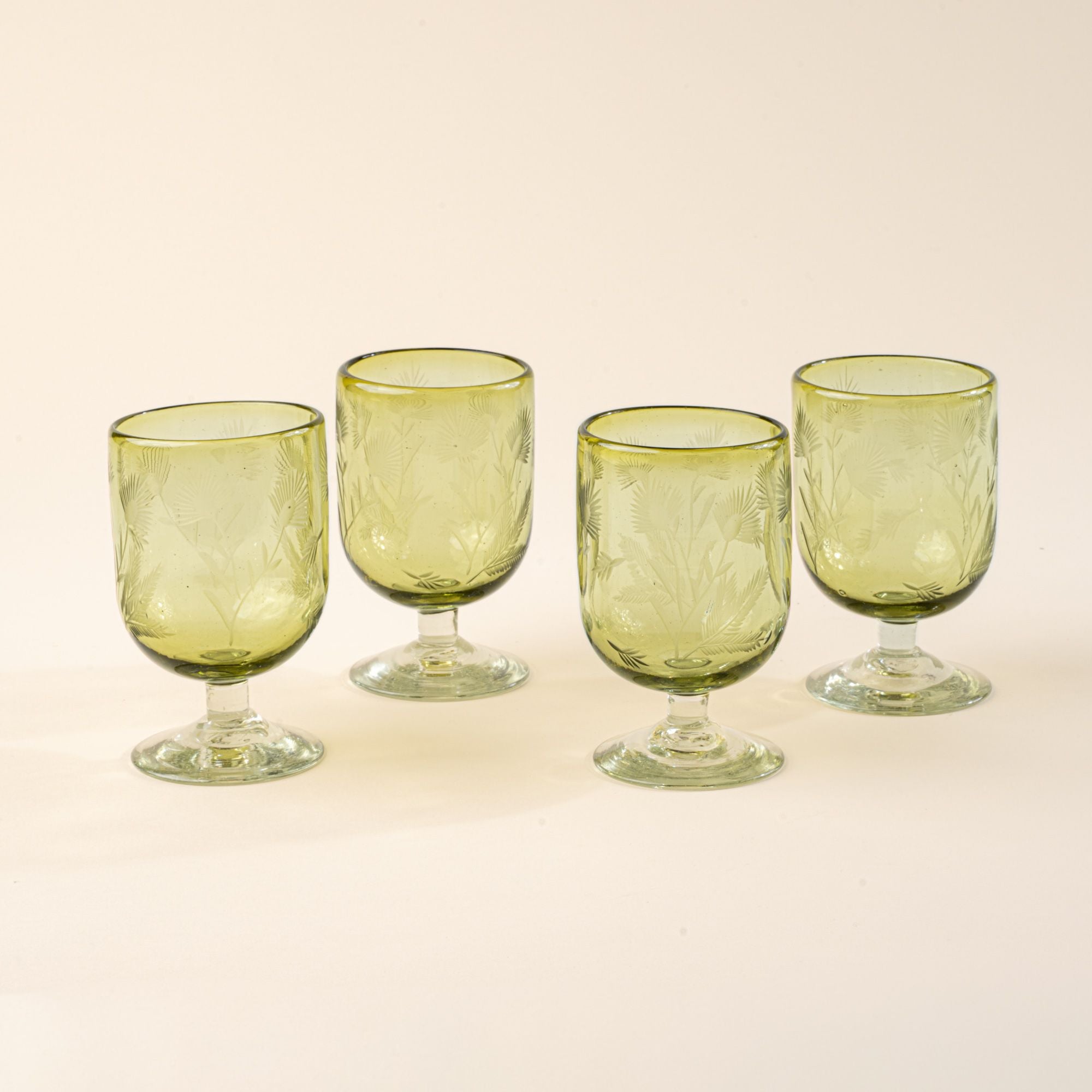 Four olive short wine glasses made of recycled glass with etched thistle designs on it