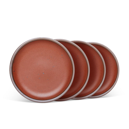 4 medium sized ceramic plates in a cool burnt terracotta color featuring iron speckles and an unglazed rim.