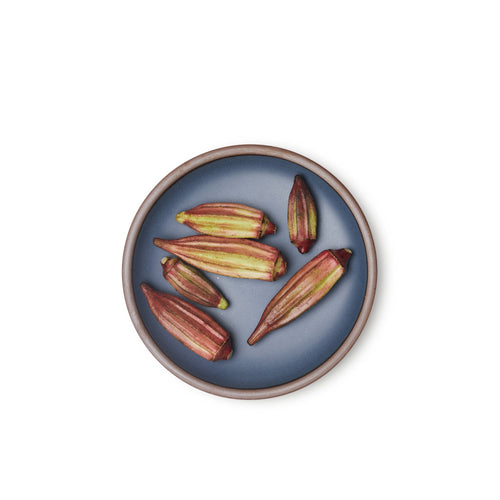 Okra on a medium sized ceramic plate in a cool, medium blue color featuring iron speckles and an unglazed rim.