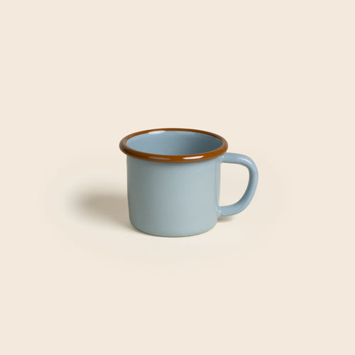 A robin's egg blue enamel mug with a glossy brown rim and handle, shown against a neutral beige background.