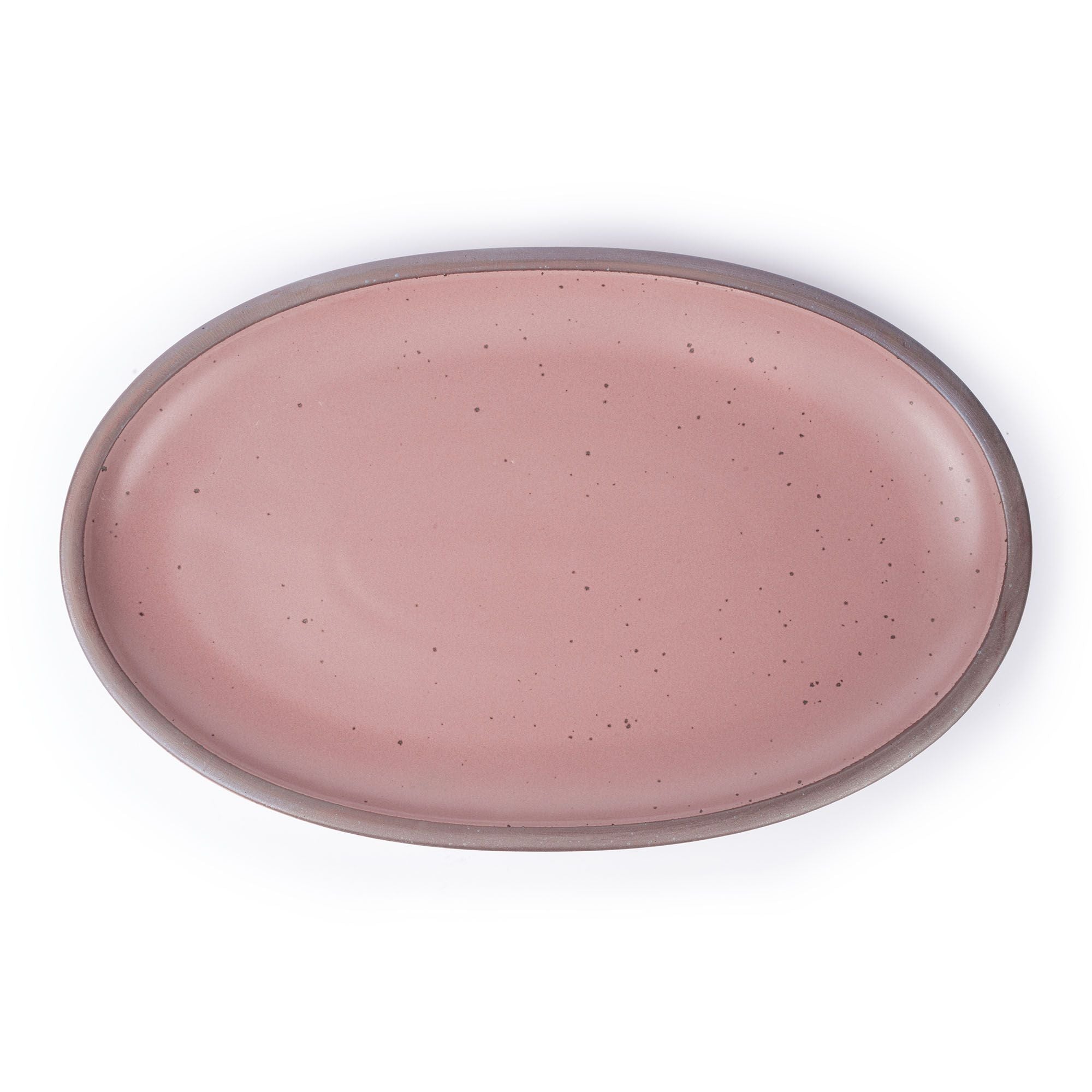 A large oval ceramic platter in a dusty mauve pink color featuring iron speckles and an unglazed rim