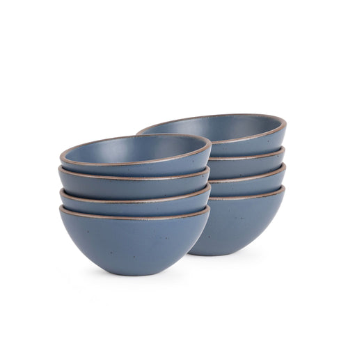 A stack of 8 medium rounded ceramic bowls in a cool, medium blue color featuring iron speckles and an unglazed rim