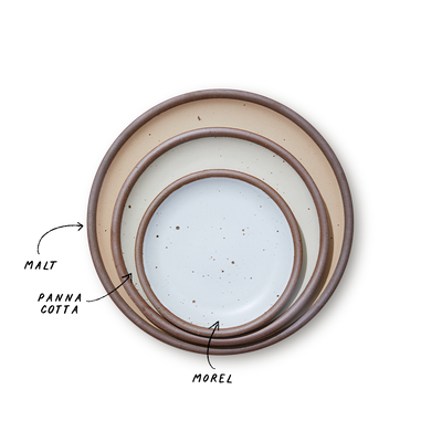A stack of 3 plates in Dinner, Side, and Cake sizes in a beige, warm off-white, and white colors.