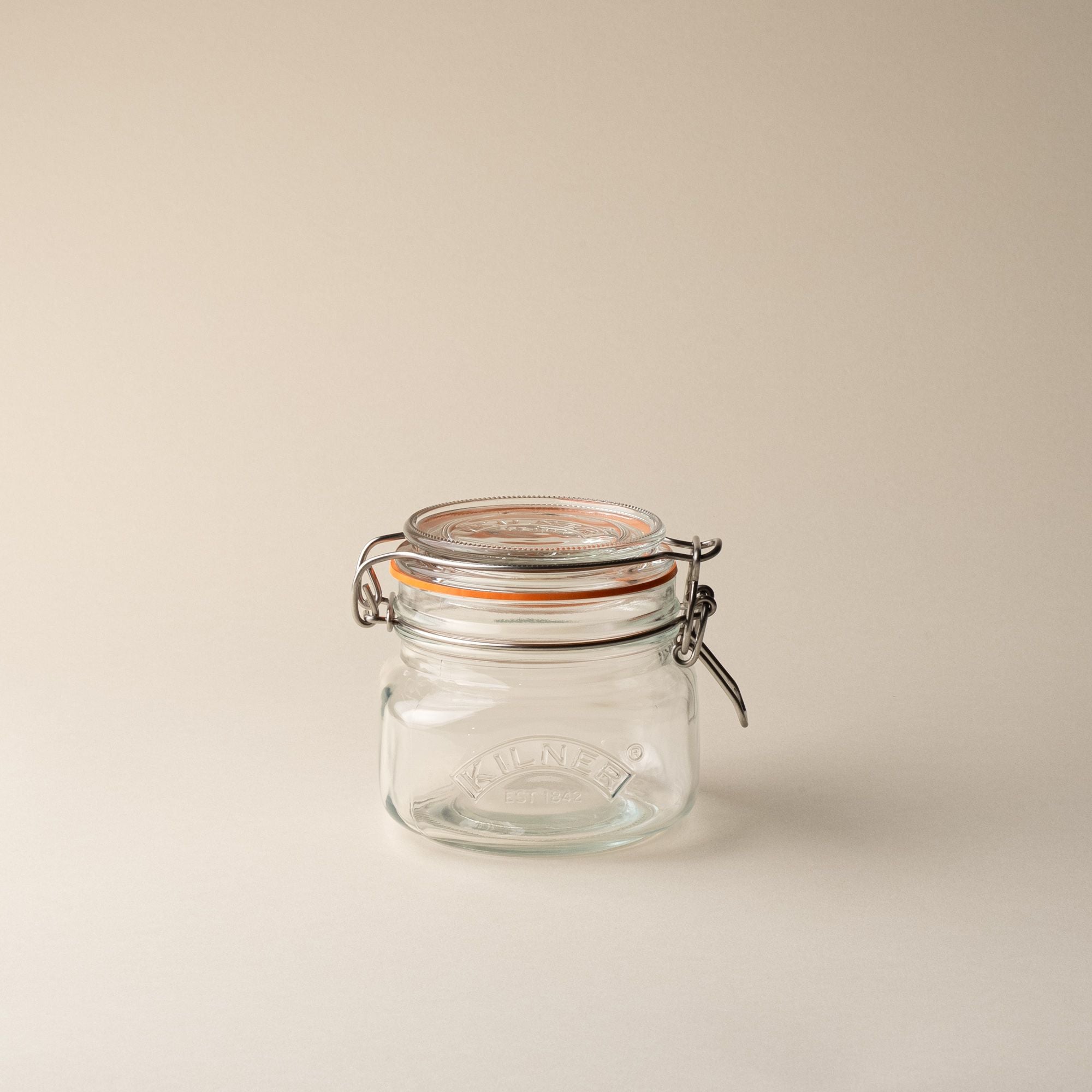 A shorter storage glass square jar, topped with a lid with a rubber seal and steel clip closure.