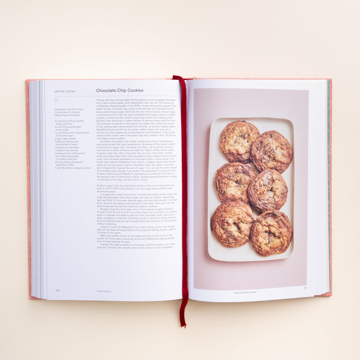 Open cookbook showing recipe text for chocolate chip cookies with a photo of six golden-brown cookies on a tray.