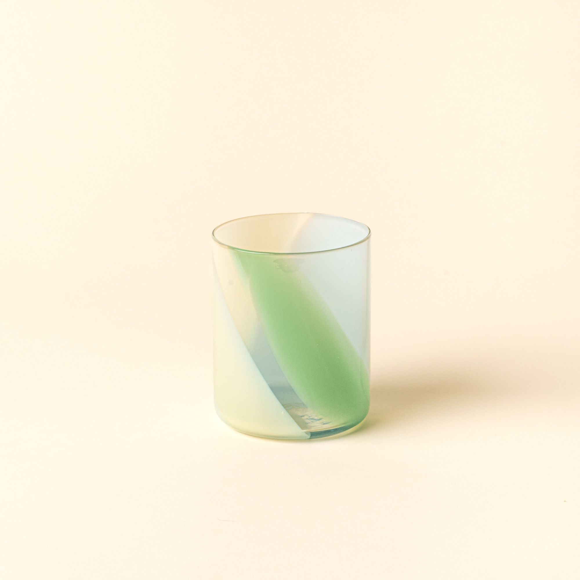 Hand-blown tumbler featuring a soft pastel green swirl design, displayed against a neutral background.