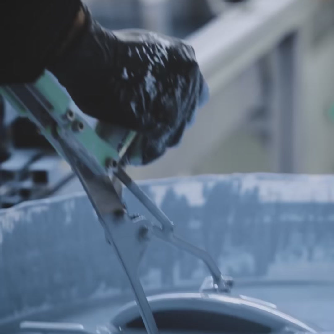 A hand dipping a ceramic plate in a bucket of blue glaze, someone applying a decal to a mug.