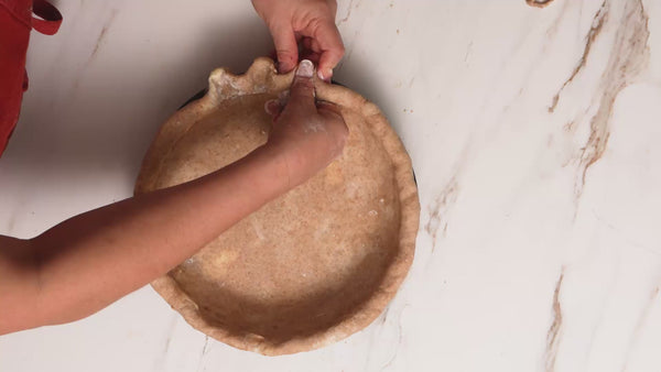 A video of someone making and baking a pie, cinnamon rolls, serving pie and dishes on a countertop.