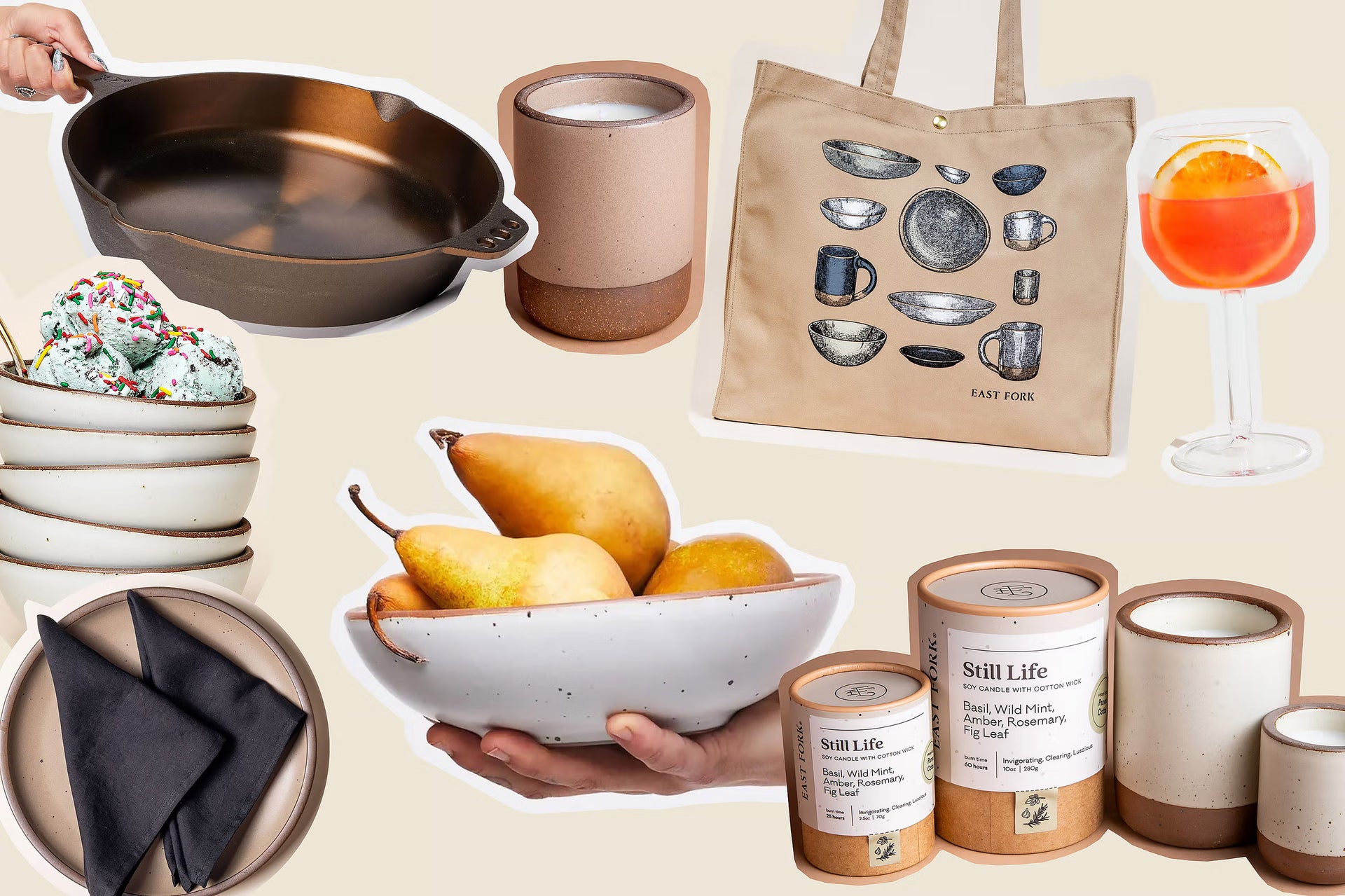 A collage of various items including a cast iron skillet, a beige tote bag with pottery illustrations, a clear glass with an orange slice, a stack of bowls with ice cream and sprinkles, a bowl with pears, black napkins on a plate, and several soy candles labeled "Still Life".