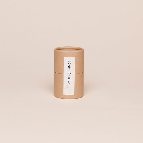 Brown paper cylinder with a vertical white label that has Japanese writing on it