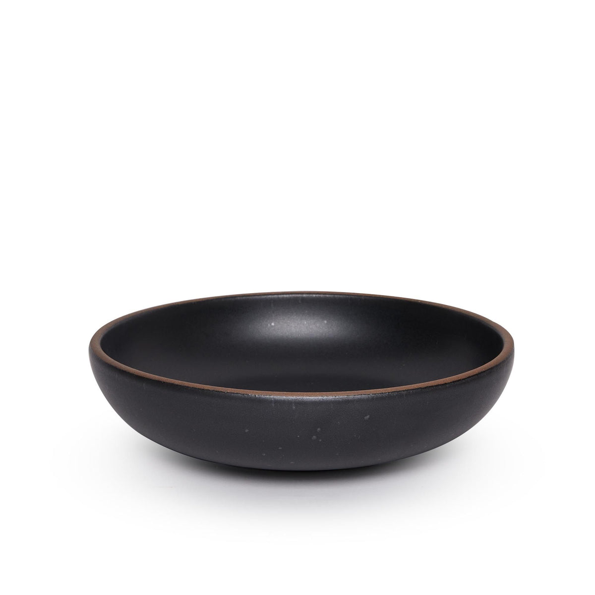 A large shallow serving ceramic bowl in a graphite black color featuring iron speckles and an unglazed rim