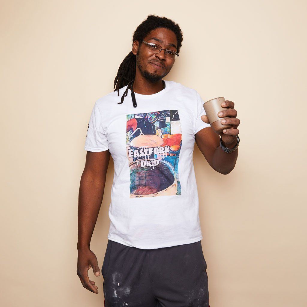 A person wears a white Drip Life tee and holds an East Fork Juice Cup.