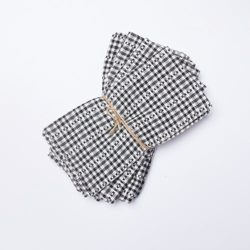 Stack of four black and white gingham napkins tied with a string