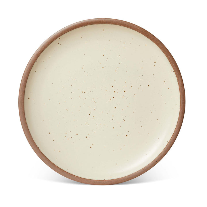 A large ceramic platter in a warm, tan-toned, off-white color featuring iron speckles and an unglazed rim.