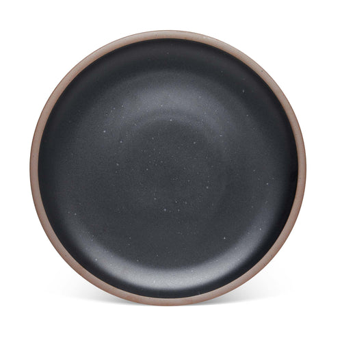 A large ceramic platter in a graphite black color featuring iron speckles and an unglazed rim.