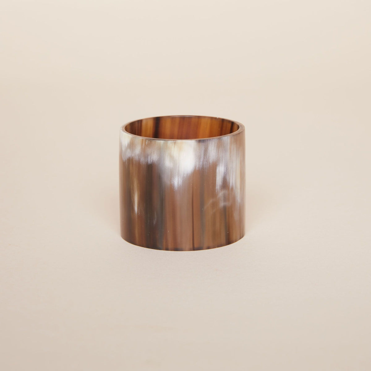 One cylindrical napkin holder with wavy vertical brown lines and accents in white