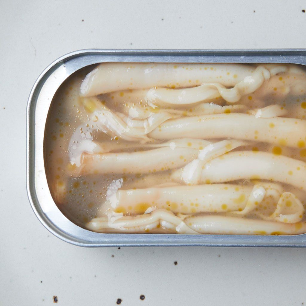 Overhead view of razor-shell clams with liquid in a tin that is open